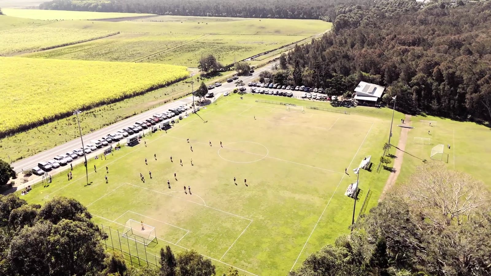 Aerial view of the Pottsville Football Club grounds on match day, surrounded by cane fields and bushland